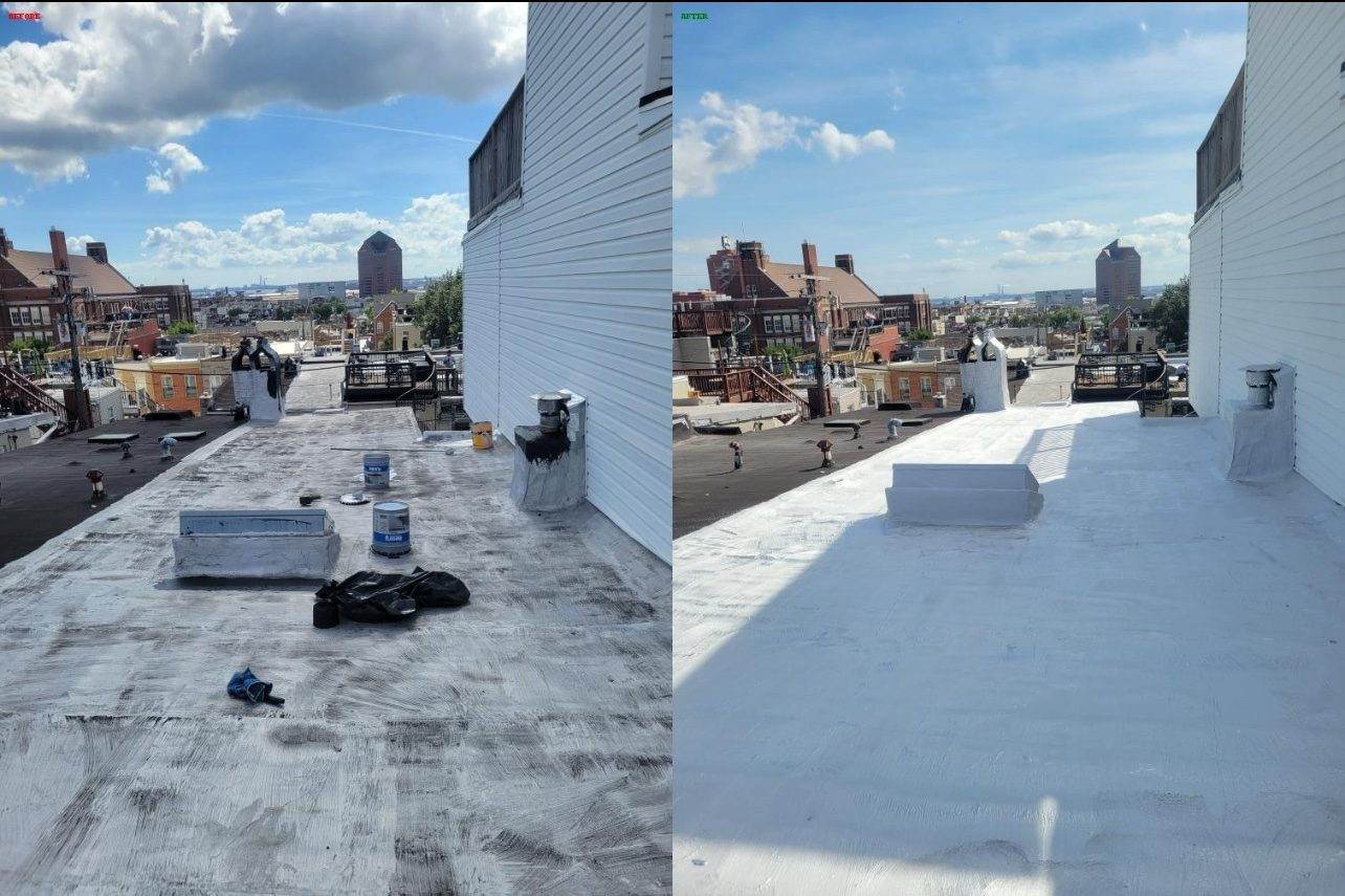 A flat roof recoated white, photographed with a city skyline beyond — typical of rowhouse roof views in the Baltimore area.