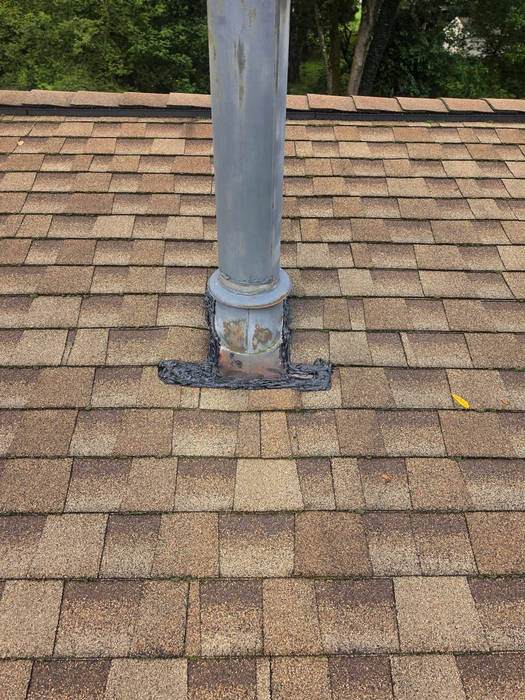 A vent pipe flashing on older shingles — aging but sound roofs like this are often good repair candidates.