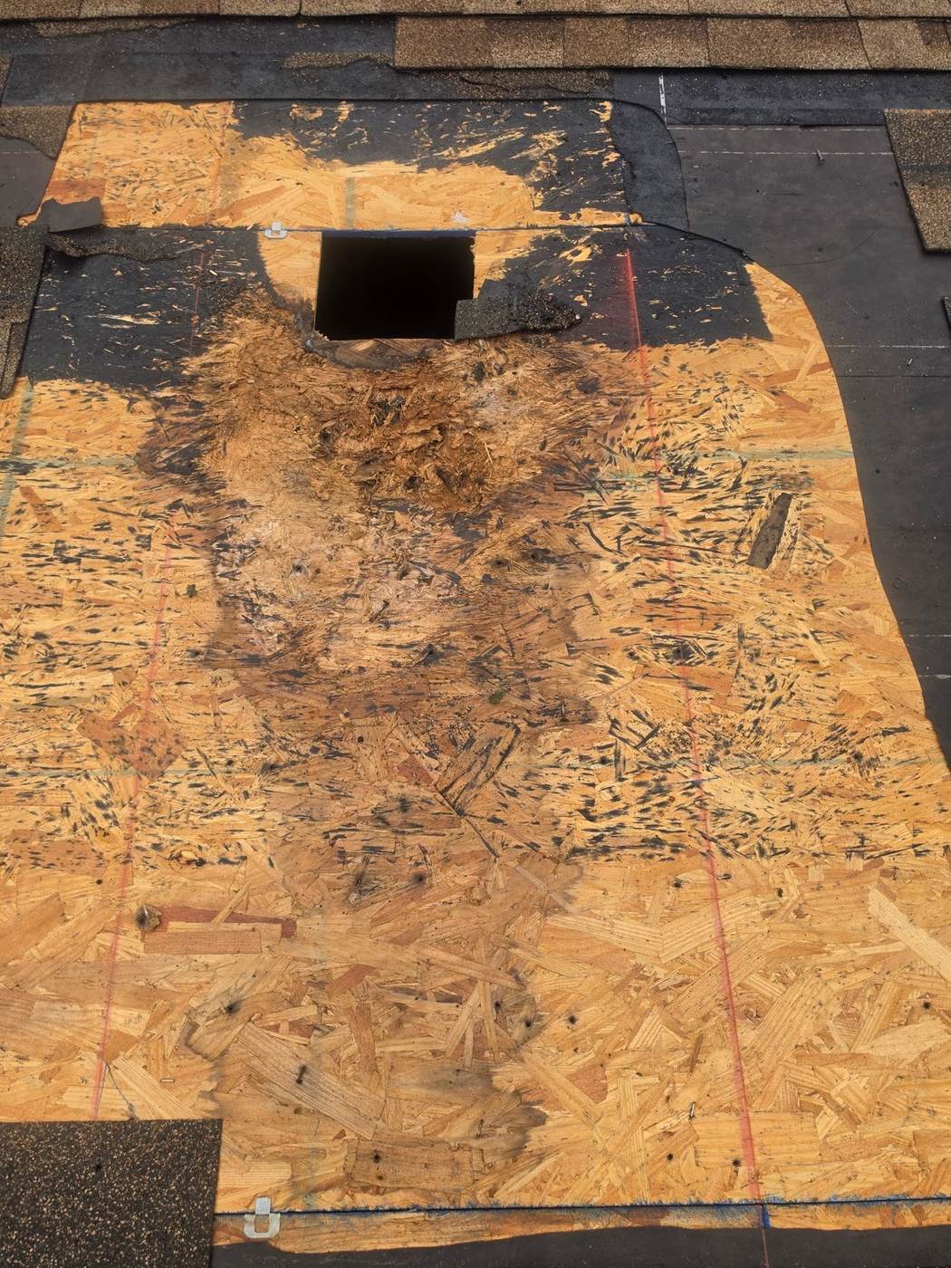 Localized damage like this — torn-back shingles exposing the sheathing around a vent — is a repair, not a replacement.